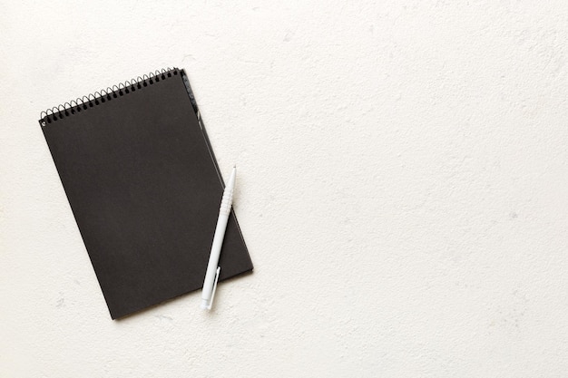 Cuaderno escolar en un bloc de notas negro espiral de fondo de color en una mesa Vista superior