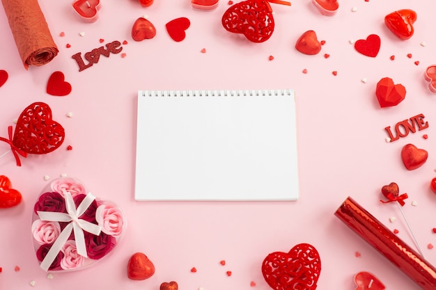 Cuaderno para escribir con corazones rojos, regalos y velas.