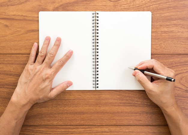 Cuaderno de escritura a mano de hombre sobre fondo de madera