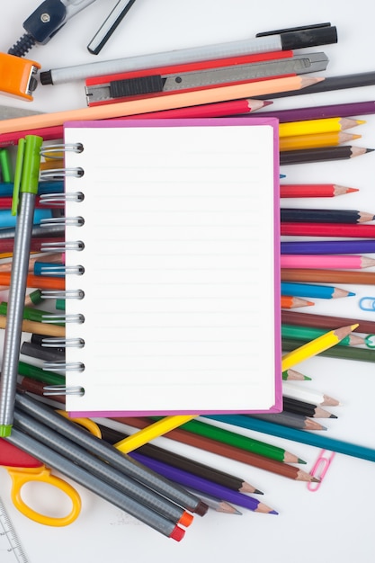 Foto cuaderno y la escuela o herramientas de oficina sobre fondo blanco y