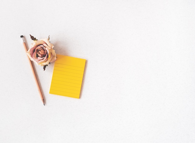 Cuaderno de espacio pastel con flor rosa y lápiz.