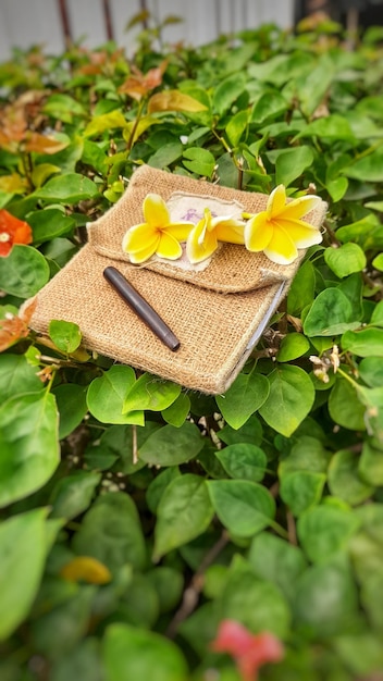 Un cuaderno con una flor y un bolígrafo