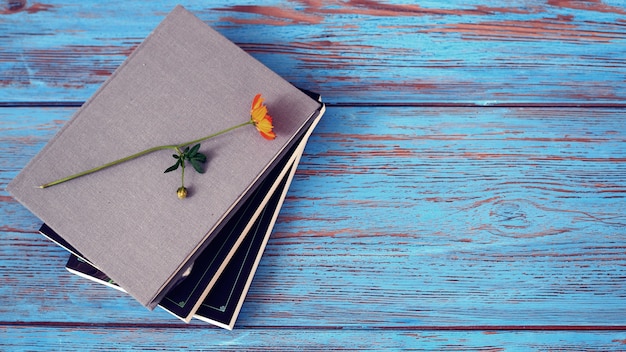 Cuaderno con flor de cosmos amarillo sobre fondo de mesa de madera