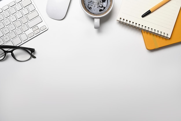 Cuaderno de gafas de teclado inalámbrico plano y planta suculenta en el escritorio de oficina blanco