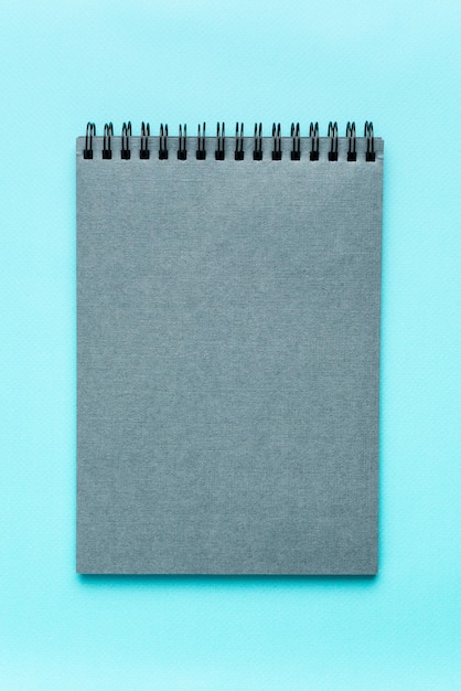 Foto cuaderno gris sobre un papel gris mocap de fondo azul