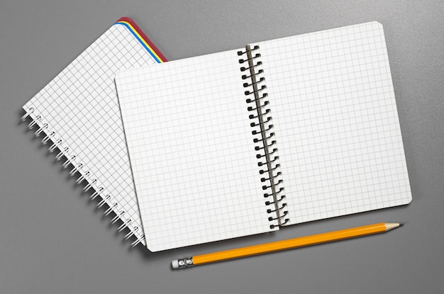 Cuaderno y lápiz abiertos en el escritorio gris, vista superior