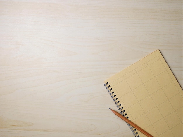 Cuaderno y lápiz sobre fondo de textura de madera