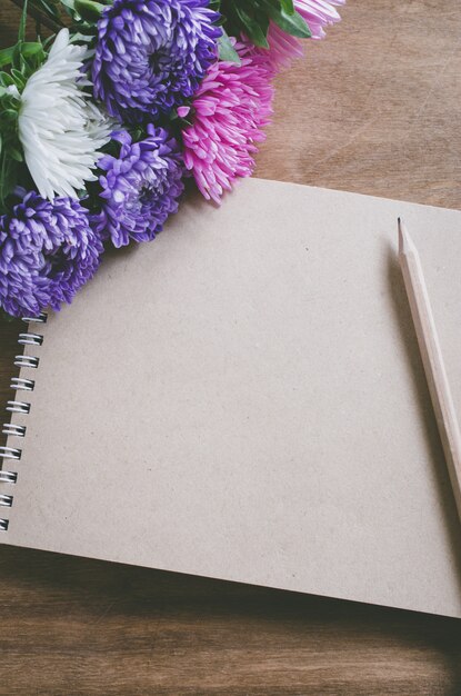 Cuaderno marrón en blanco con flores de otoño.