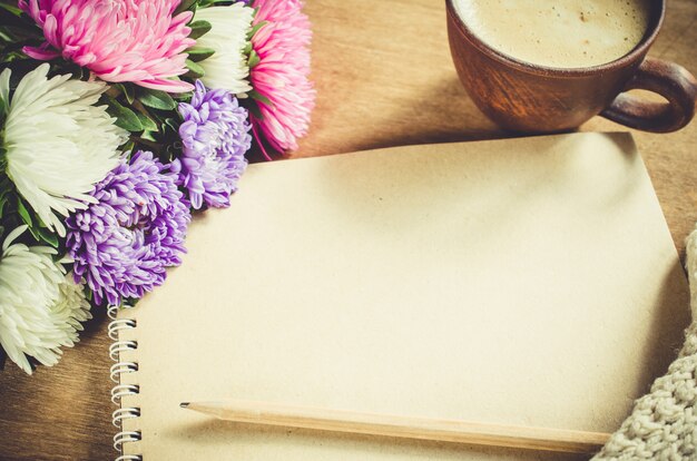 Foto cuaderno marrón en blanco con flores de otoño.