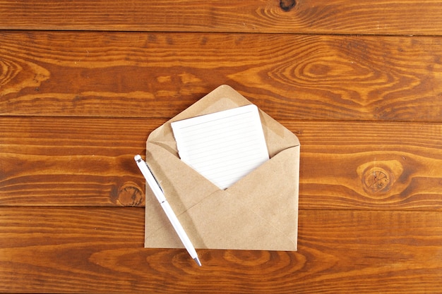 Cuaderno marrón con bolígrafo blanco sobre un fondo de mesa de madera