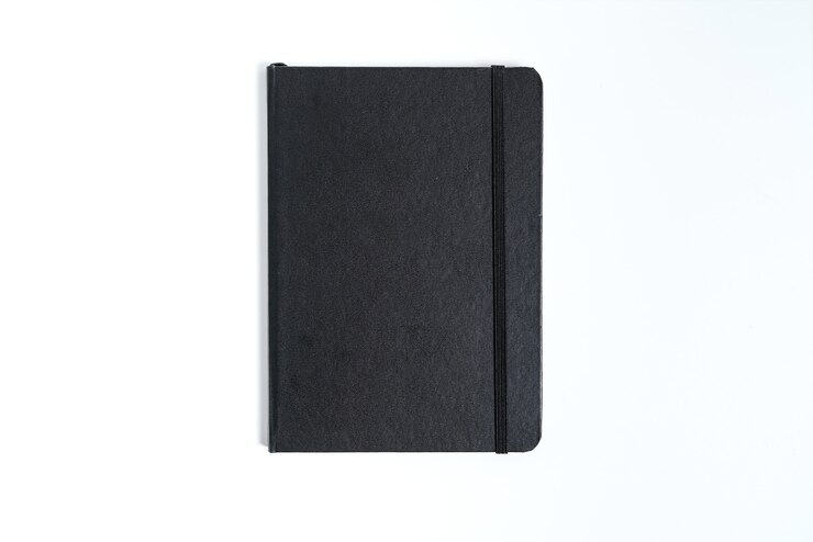 Cuaderno negro sobre fondo blanco con trazado de recorte