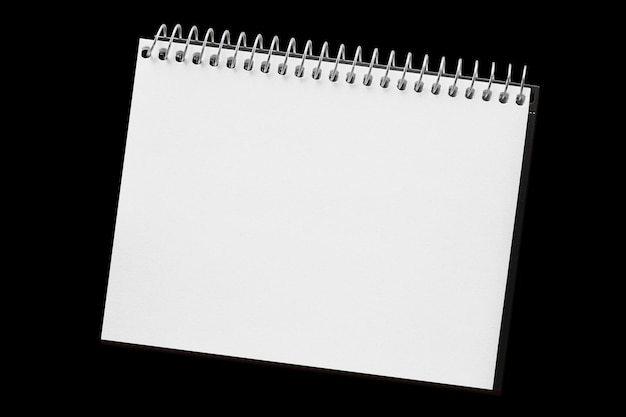 Un cuaderno de página de papel aislado en el fondo negro