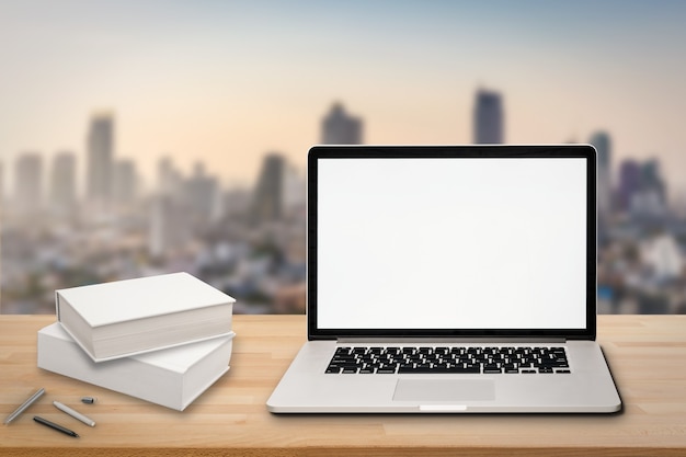 Cuaderno de pantalla en blanco sobre mesa de madera