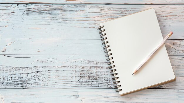 Foto cuaderno de papel en blanco y lápiz visto desde arriba en el escritorio