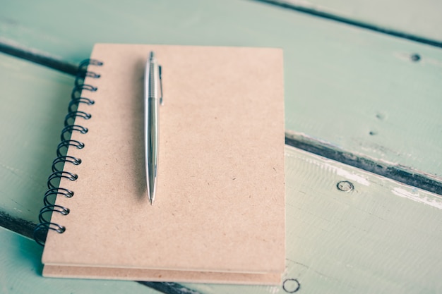 Un cuaderno de papel con una pluma en la mesa de madera, educación, negocios, concepto de vida