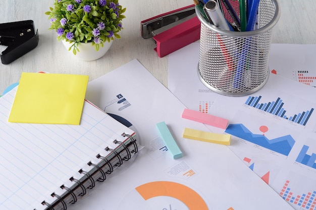 Cuaderno y papeles financieros con tablas y números.