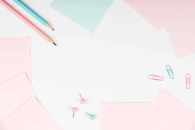 Cuaderno y pegatinas de papeles de colores sobre el escritorio blanco Múltiples colecciones variadas Papelería de oficina Foto con bolígrafos Lápices Rullers Calculadoras