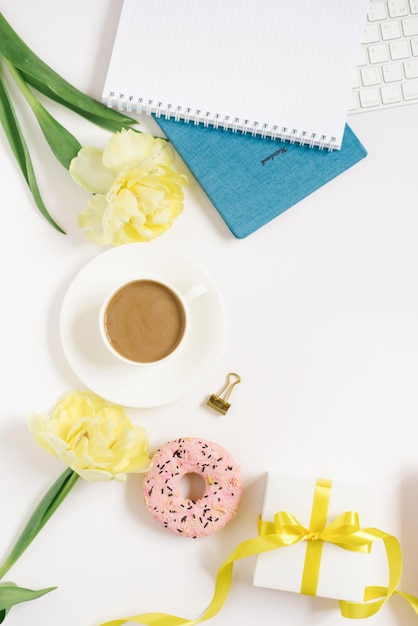 Cuaderno para la planificación diaria con desayuno servido en una taza de fondo blanco de flores de donut de café