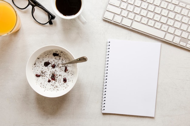 Foto cuaderno plano y tazón con pasas de yogurt y semillas de chía