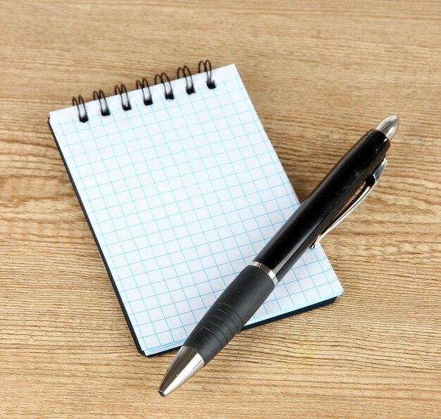 Cuaderno y pluma en la mesa de madera