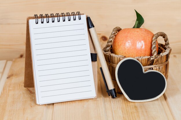 cuaderno y pluma en la tabla de madera.