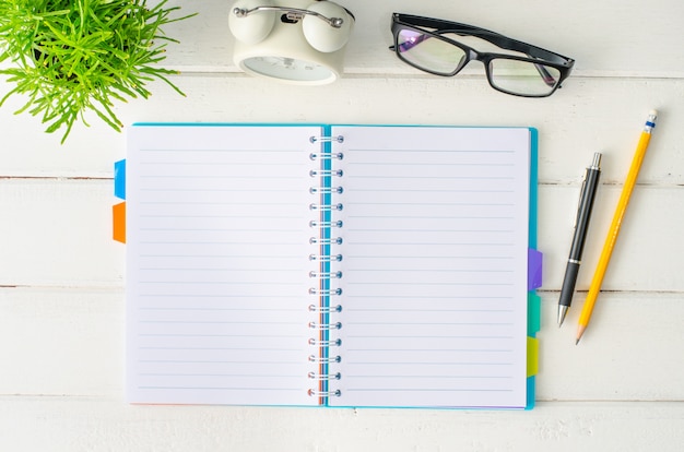 Cuaderno, pluma, zapatos, en el piso de madera blanco