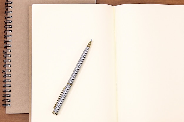 Cuaderno de primer plano con un bolígrafo sobre la mesa.