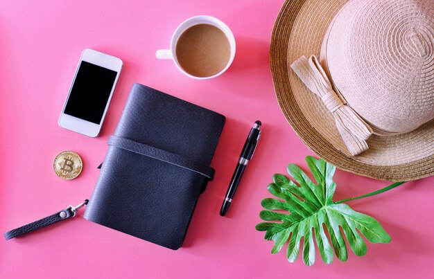 Cuaderno, Smartphone, taza de café, sombrero, Bitcoin y hoja tropical