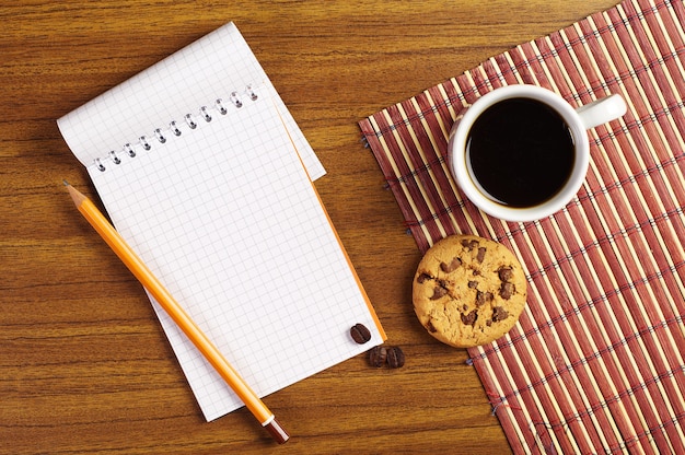 Cuaderno y taza de café con galletas de chocolate
