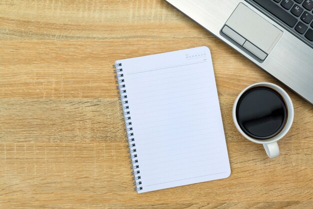 cuaderno y taza de café en la mesa de trabajo