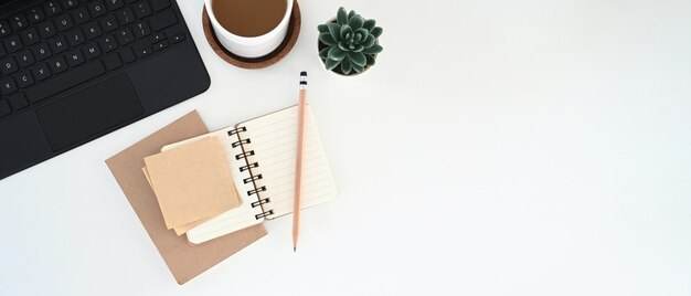 Cuaderno, taza y teclado en el escritorio