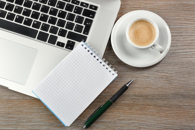 Cuaderno vacío en el teclado del portátil sobre fondo claro