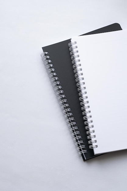 Cuadernos en blanco y negro en el escritorio blanco