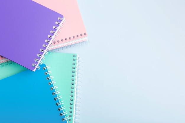 Cuadernos de colores, lápices de colores sobre una mesa de luz Lugar para el texto