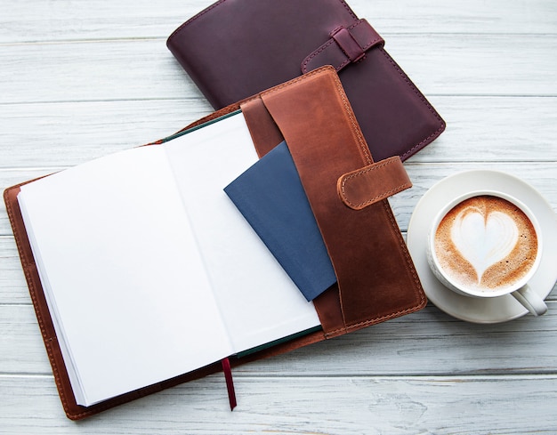 Cuadernos de cuero y taza de café.