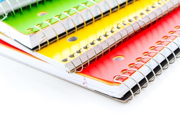 Cuadernos de espiral multicolores sobre un fondo blanco.