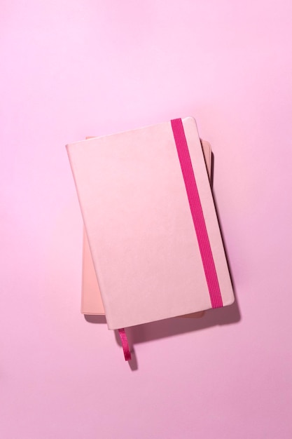 Cuadernos de vista superior en escritorio rosa