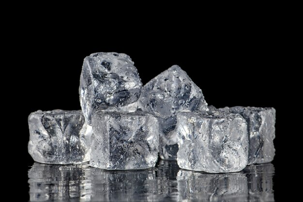 Cuadrado de cubitos de hielo con gotas de agua limpia en negro