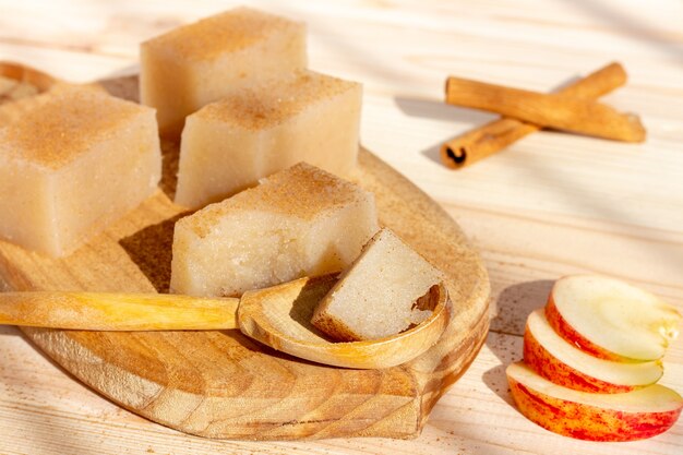 Cuadrados de gelatina de manzana casera con canela en mesa de madera.