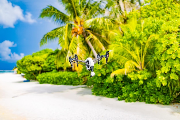 Cuadricóptero de drones profesional con cámara digital en playa tropical. Tomando imágenes de la luna de miel