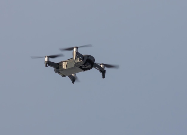 Un cuadricóptero volador en el fondo del cielo gris