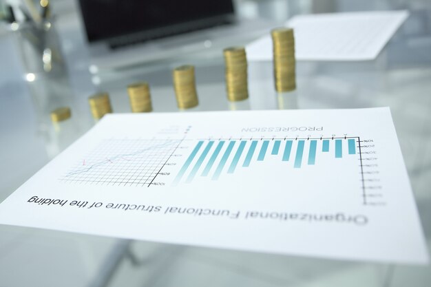 Cuadro financiero y pilas de monedas en el escritorio de la oficina. foto con espacio de copia