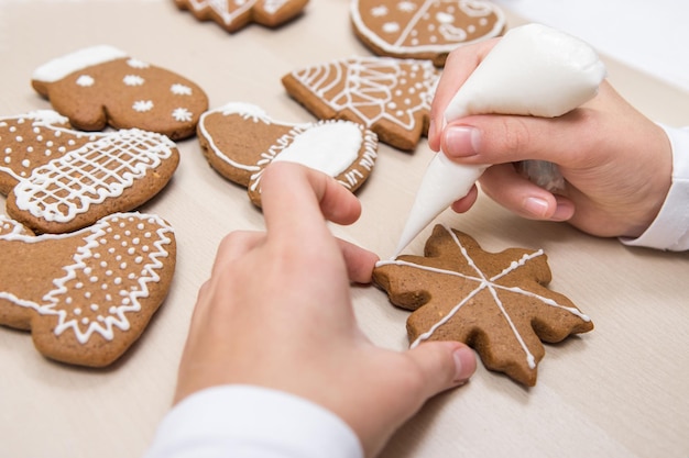 Cuadro de pan de jengibre navideño El niño pone hielo en el dibujo de la galleta