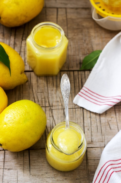 Cuajada de limón casera con tarros y limones sobre fondo de madera