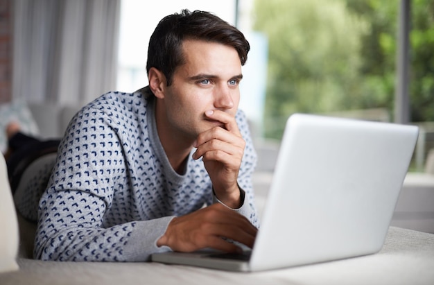 Cuando intentas recordar cuál es tu contraseña Captura de un joven contemplando mientras usa su computadora portátil