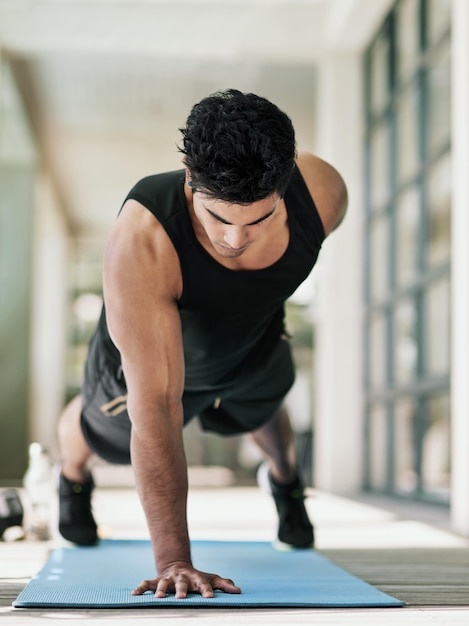 Cuando piense en dejar de fumar, recuerde por qué comenzó Toma de un joven haciendo flexiones durante su entrenamiento en casa