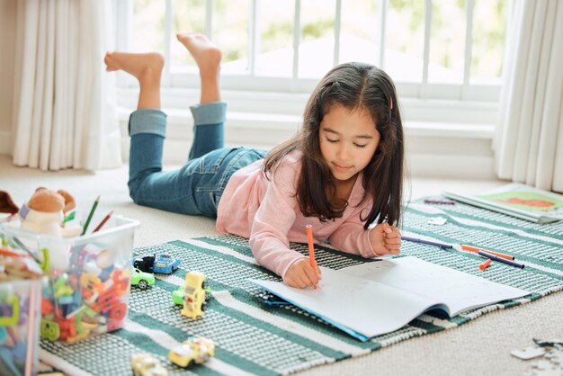 Cuanto más aprendes, más creces Fotografía de una niña pequeña haciendo la tarea en casa