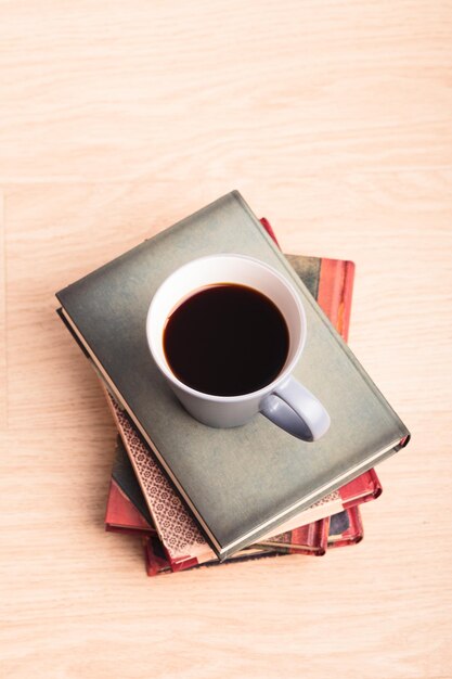 Unos cuantos libros con una taza de café en el suelo relajándose con la lectura tiempo de ocio con libros