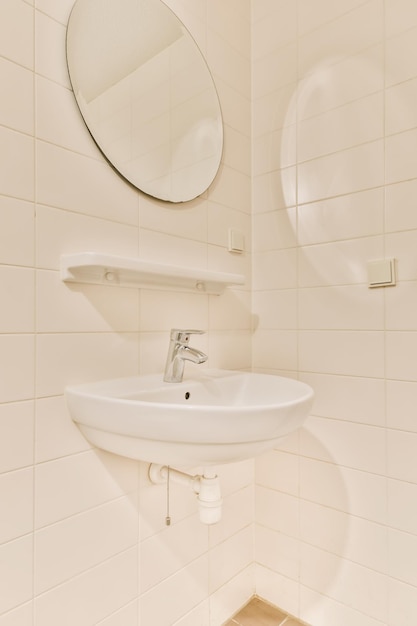 Un cuarto de baño con un lavabo y un espejo en la pared junto a él es un toallero que se ha colocado en frente de la