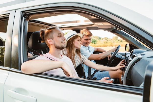 Cuatro amigos en la navegación del coche en el teléfono. viaje